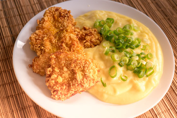 Chicken schnitzel with mashed potatoes on the plate.
