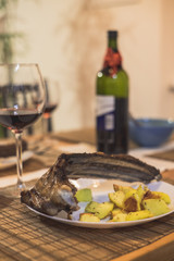 Roasted ribs with baked potatoes on the plate. Red wine.