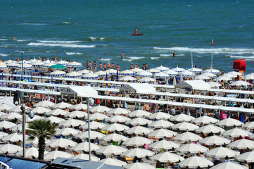 Riccione, Italy, June 18, 2018. Beach umbrellas, tourists, gazebos and sun beds at Italian sandy...