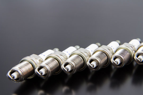 New spark plug isolated on a black gray background