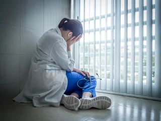 Tired doctor sitting alone in hospital floor © mybixo