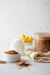 BULLETPROOF CACAO. Ketogenic keto diet hot drink. Cacao blended with coconut oil and butter. Cup of bulletproof cacao and ingredients on white background