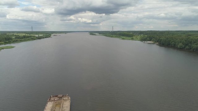 Aerial view:Barge with cargo on the river Volga. River tugboat moves cargo barge, Cargo ship on the river.