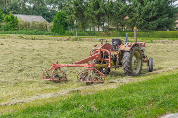 old tractor with plow in the fields