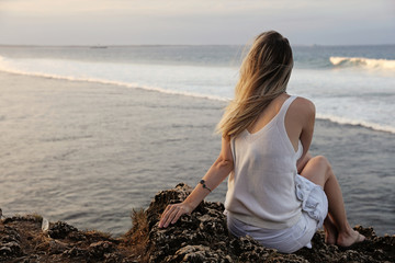 Calm, relax ,mind reset concept. Young woman sitting on top of the cliff , breathing fresh air and...