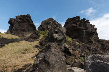 Three Saints Island, Taitung Taiwan, Pacific Coast. Sanxiantai scenic area rock formations, black coral reef and green grass foreground. pedestrian boardwalk and blue sky in the background