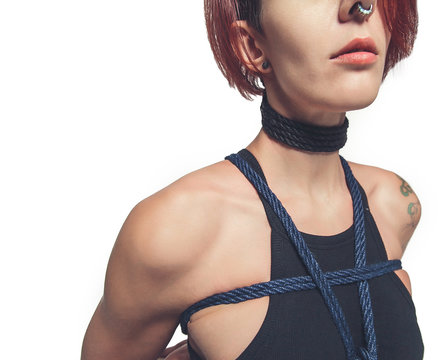 portrait young alternative girl in tattoos. Red hair  a shibari rope