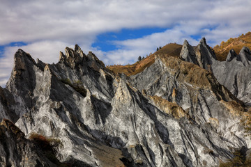 Bamei stone forest, exotic pillars of gray stone situated in the grasslands of Sichuan Province, China. Unique rock formations with blue sky in the distant background. Kangding and Xinduqiao scenery