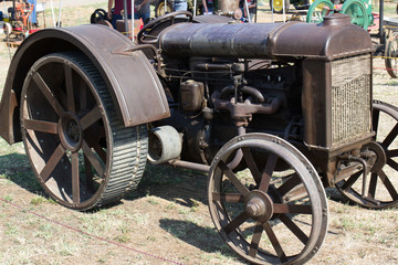 Fototapeta na wymiar Vintage Rusted Metal Tractor With Unique Wheels