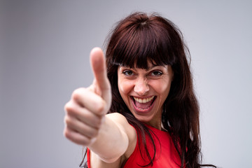 Happy enthusiastic woman giving a thumbs up