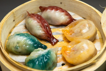 Closeup of colorful dim sum in a steamer wooden basket