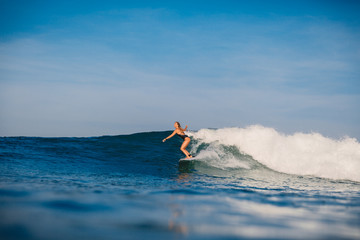 Surf girl on surfboard. Woman in ocean during surfing. Surfer and wave