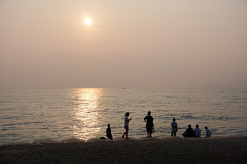 peaple are looking the sea when sunrise