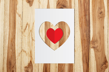 Paper heart shape with red heart on wooden background