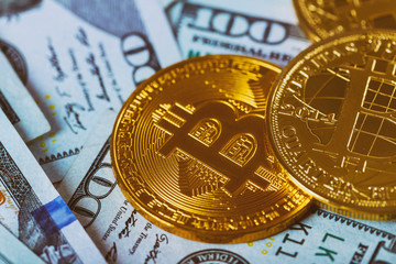 Gold Bitcoin on hundred dollars bills. Bitcoin on us dollar bills electronic money exchange concept. Close-up.