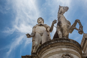 Obraz premium Looking up at a statue of Pollux and his horse at the top of the steps to the Capitoline Museum in Rome