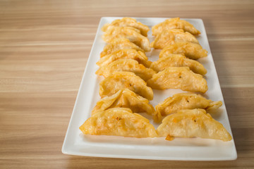 Gyoza in plate on wood