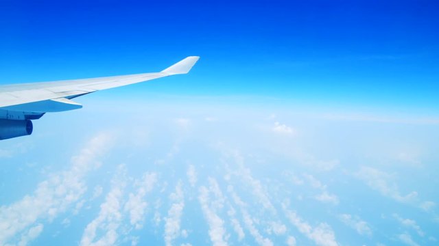 Bright blue sky and wing seen from inside an airplane