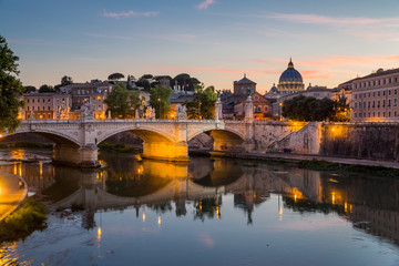 Obraz na płótnie Canvas View of St Peter's Cathedral and the Tiber river from Pont Sant'Angelo at dusk