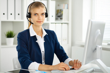 Modern business woman with headset in the office. Customer service operator at home work place. Success start up concept