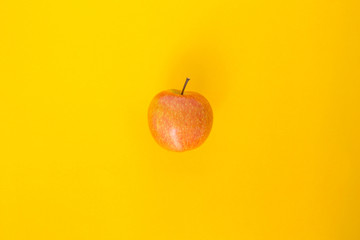 red apple top focus on yellow background
