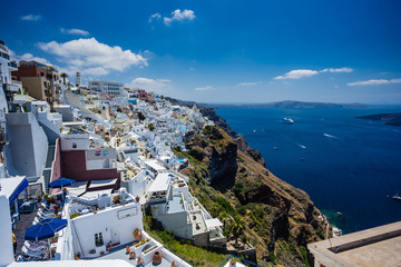 Gourgeous view from white walled town of Fira in Santorini, Greece, with ocean, cliffs and caldera of Santorini in the background.
