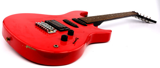 Red electric guitar with white backdrop.