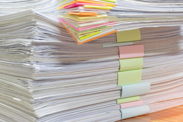 Close up pile of unfinished homework assignment stacked in archive with colorful papers on...