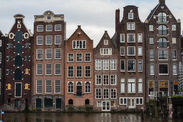 Fototapeta na wymiar Traditional Dutch houses on the banks of the canal in the center of Amsterdam. Netherlands