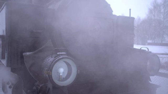 Steam locomotive of narrow gauge railway close up of locomotive front with red snow bucket - winter