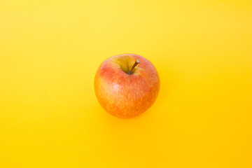 red apple top focus on yellow background