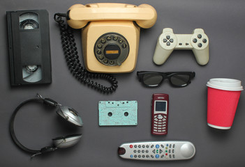 Retro objects on gray background. Rotary telephone, audio cassette, video cassette, gamepad, 3d...
