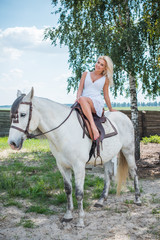 Nice happy woman enjoying horse company. Young Beautiful Woman dressed lace summer dress  With white Horse Outdoors, stylish girl at american country style. Romantic moments 