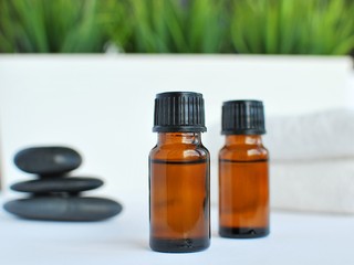 Bottles with massage essentials oils, towels and zen stones. Spa composition.