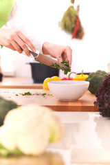 Close Up of human hands cooking vegetable salad in kitchen on the glass table with reflection. Healthy meal, and vegetarian food concept