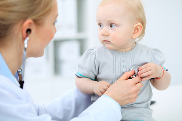 Doctor and patient in hospital. Little girl is being examined by pediatrician with stethoscope. Medicine and health care