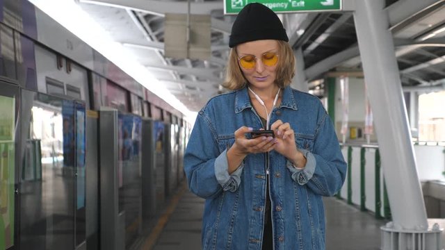 Fashionable Woman Using Cellphone Waiting For City Train