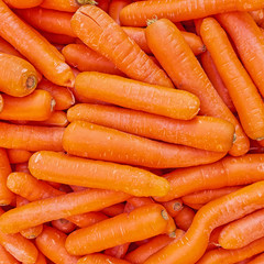fresh carrots top view, natural orange background