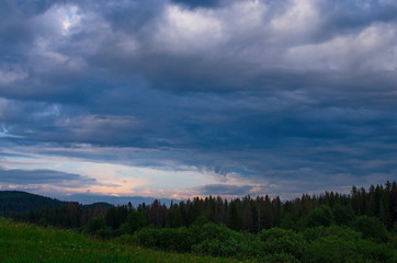sunset in the forest against a background of clouds