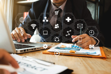 Big data analytics with business intelligence (BI) concept. businessman using mobile phone and laptop computer on white desk with VR chart and graph with icon