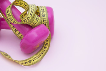 dumbbells and tape measure, concept of diet and exercise