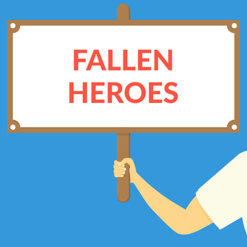 FALLEN HEROES. Hand holding wooden sign
