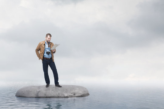 Lost In Ocean Man Tourist Looking At Map On Rock