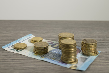 Currency, shiny euro coins and banknote on a decorated wood table