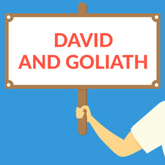 DAVID AND GOLIATH. Hand holding wooden sign