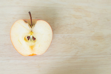 half red apple on wood background