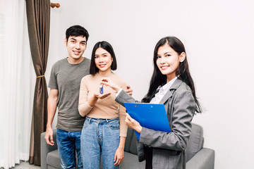 Fototapeta premium Real estate agent giving keys for couple at a house for sale.business and real estate concept