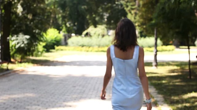 Young girl model walk in solar summer park. Slow motion