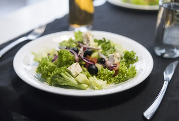 Caesar salad with chicken fillet and parmesan cheese, onion, olives, salad.
