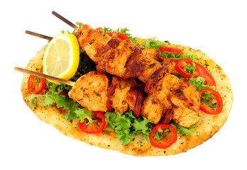 Chicken and chorizo kebabs with salad on a naan bread isolated on a white background
